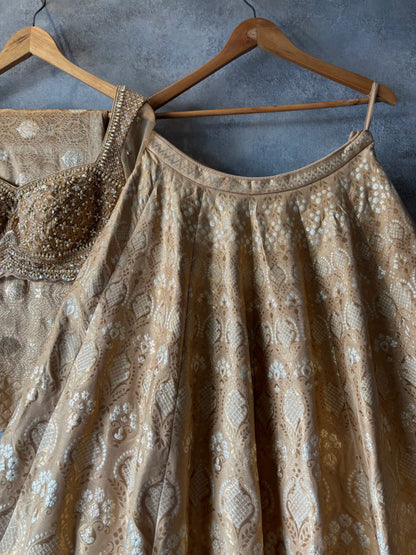 Brown embroidered dress on a hanger against a gray wall