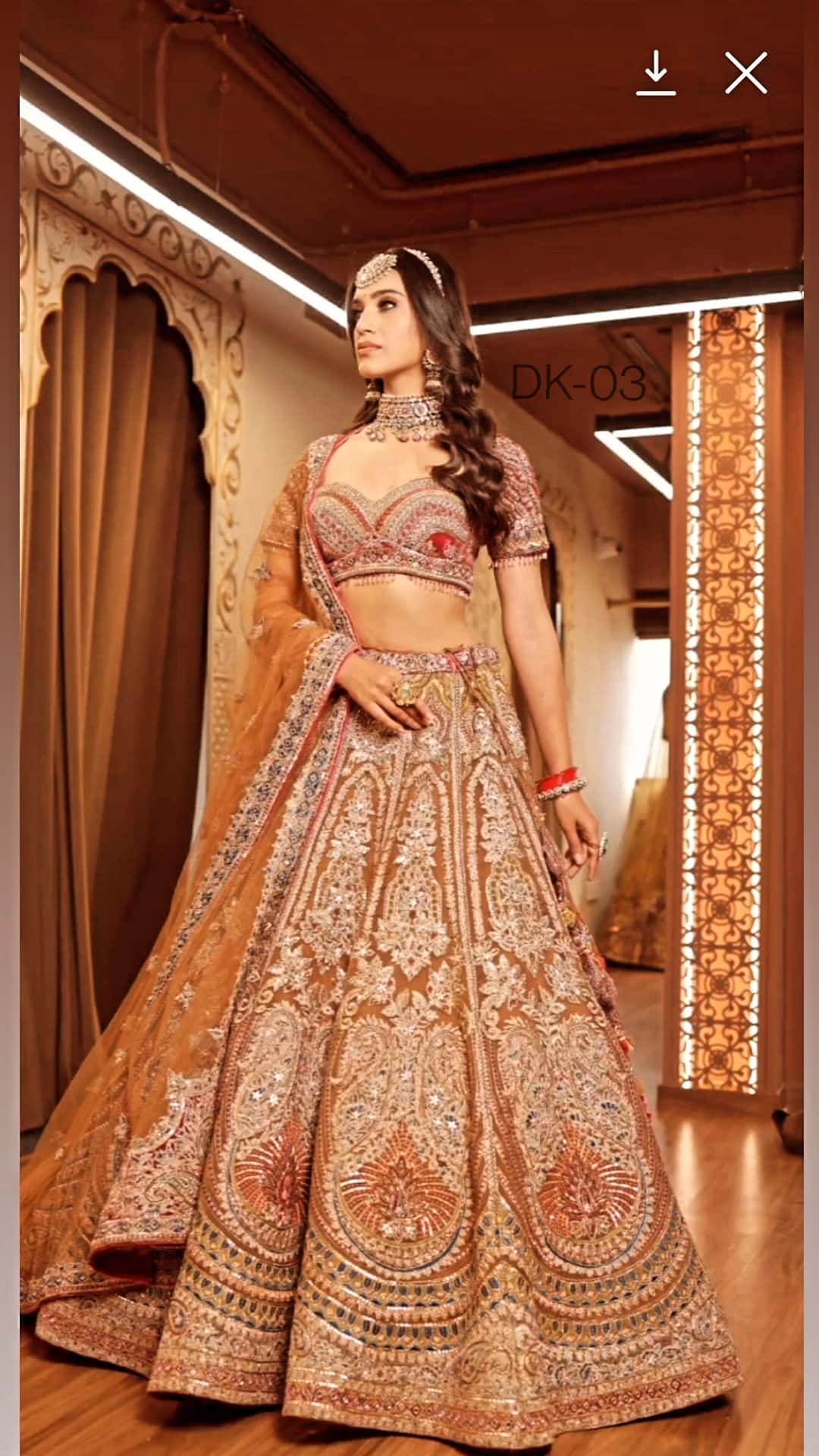 Woman in a traditional embroidered outfit standing in a decorated room.

