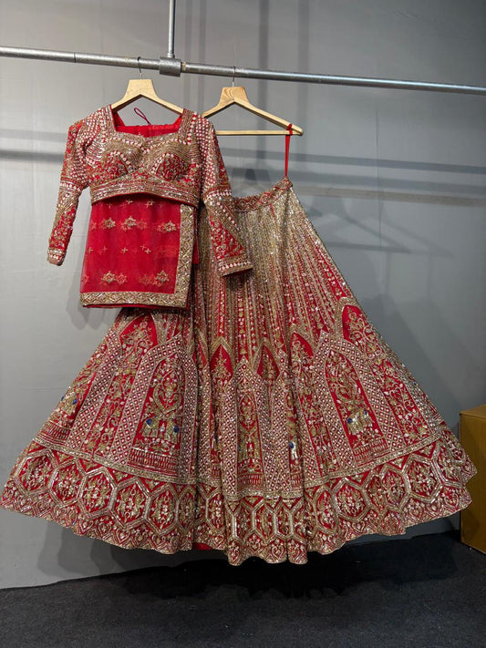 Traditional red and gold embroidered lehenga on a hanger against a gray background