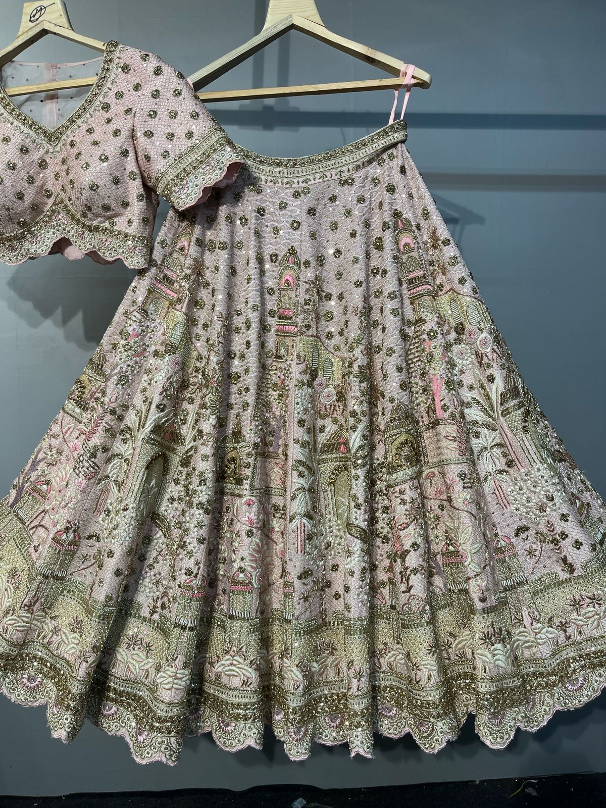 Traditional embroidered skirt and top on hangers against a gray background