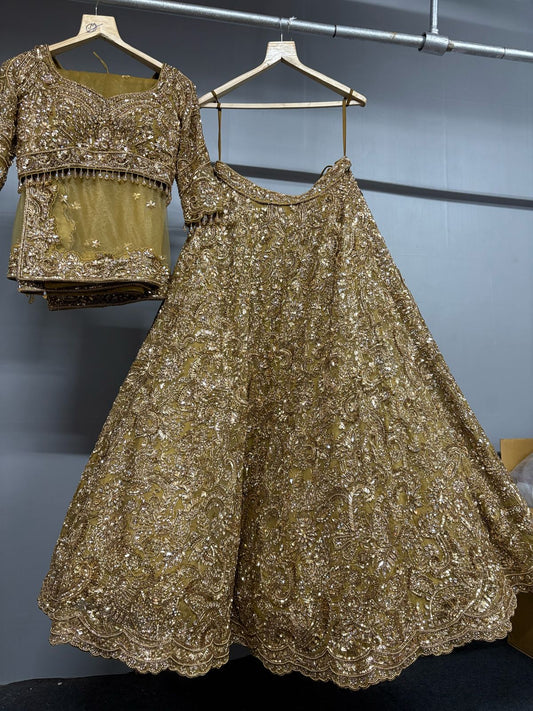 Gold sequined outfit on hangers against a gray wall