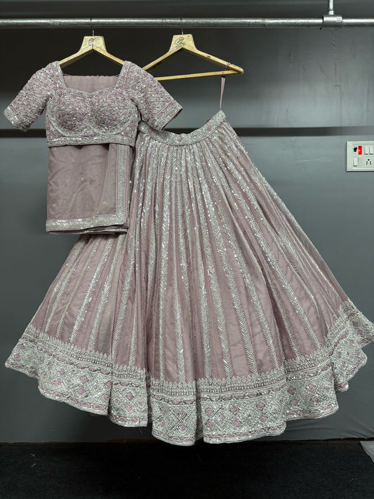 Gray embroidered lehenga with blouse on a hanger against a dark background