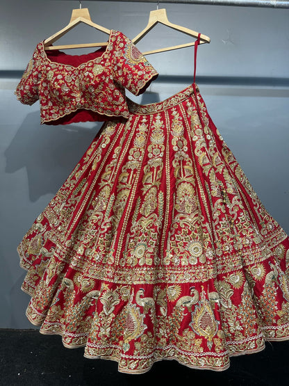 Red and gold embroidered traditional outfit on hangers against a gray background