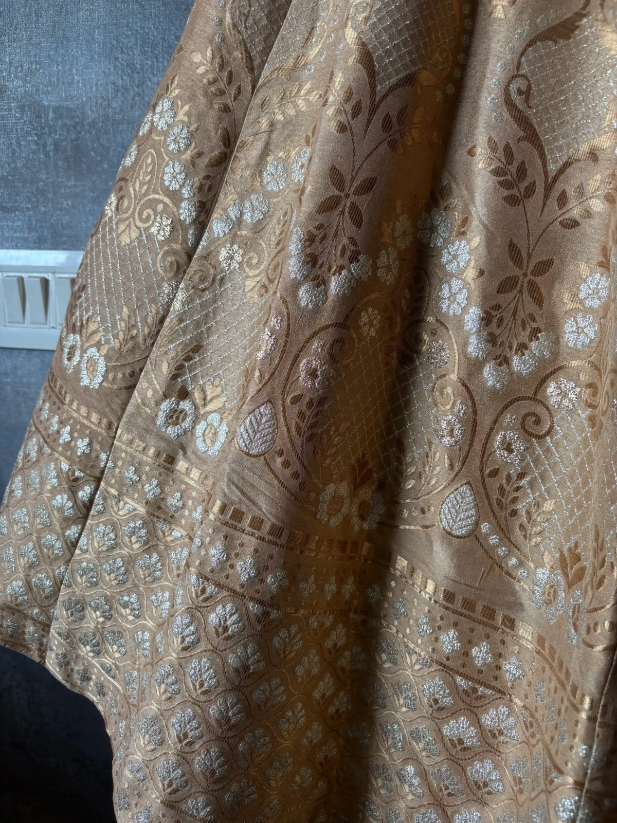 Close-up of patterned fabric with intricate designs on a plain background