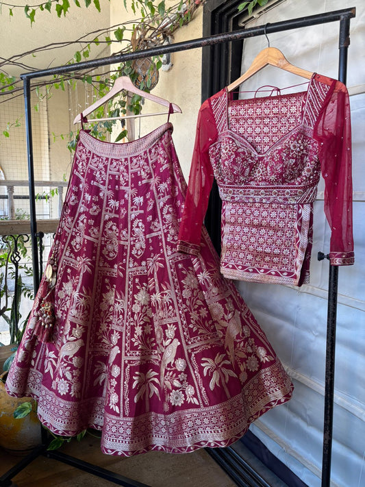 Maroon and white patterned traditional outfit on a rack with a blurred indoor background