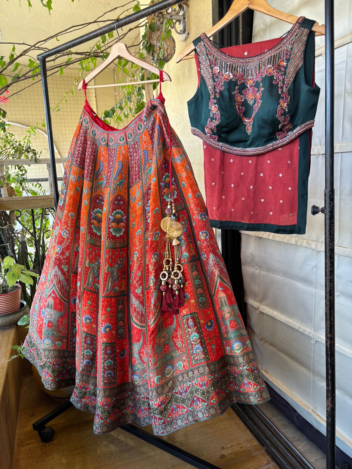 Traditional Indian outfit with a skirt and blouse hanging on a rack.