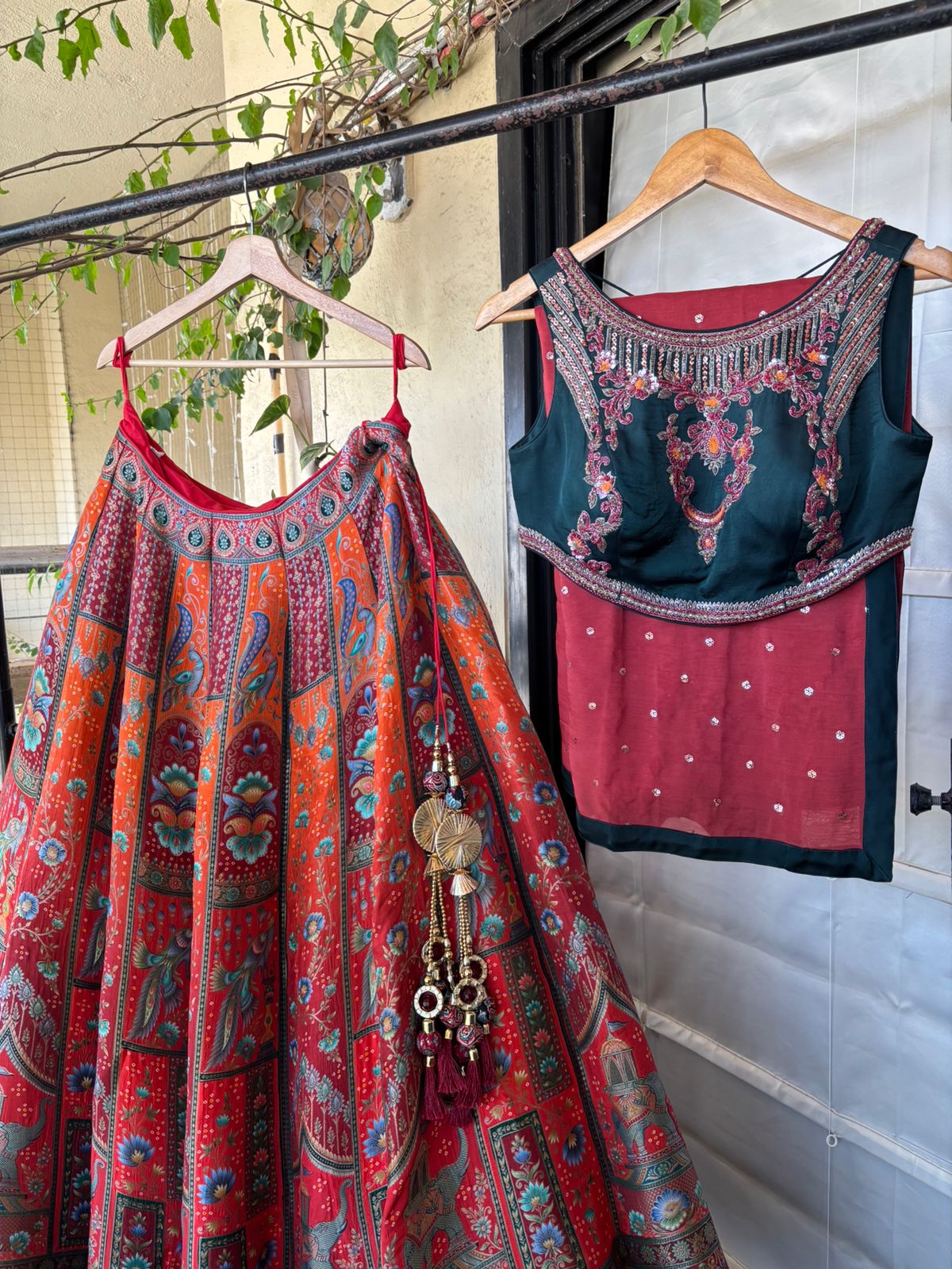 Traditional Indian outfit with a colorful skirt and embroidered top hanging on a rack.
